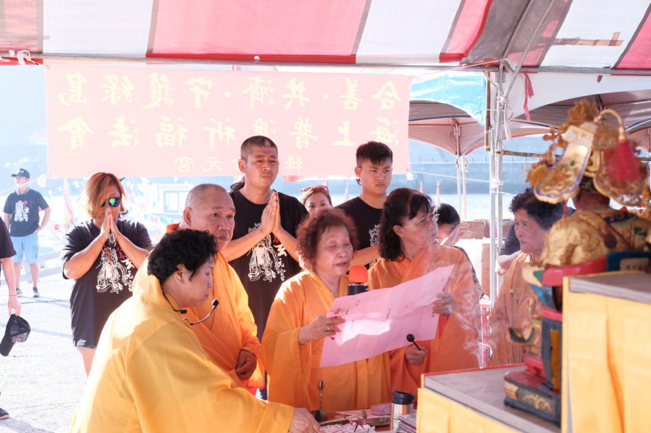 Ritual experts reading a religious petition to deities during a ceremony on Green Island